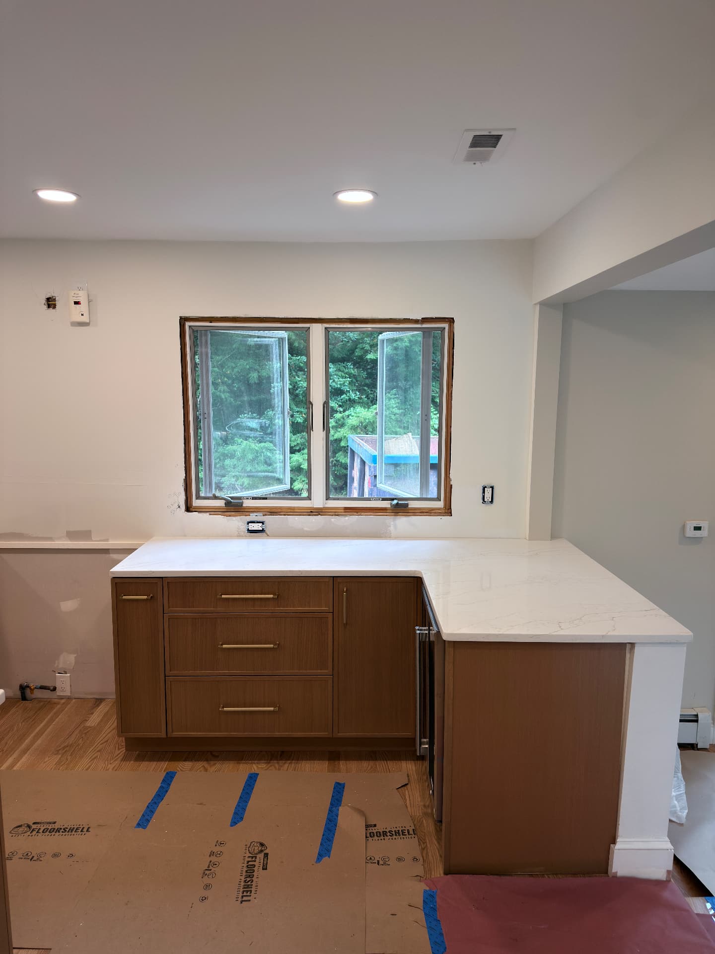 White quartz L-shaped counter under a window