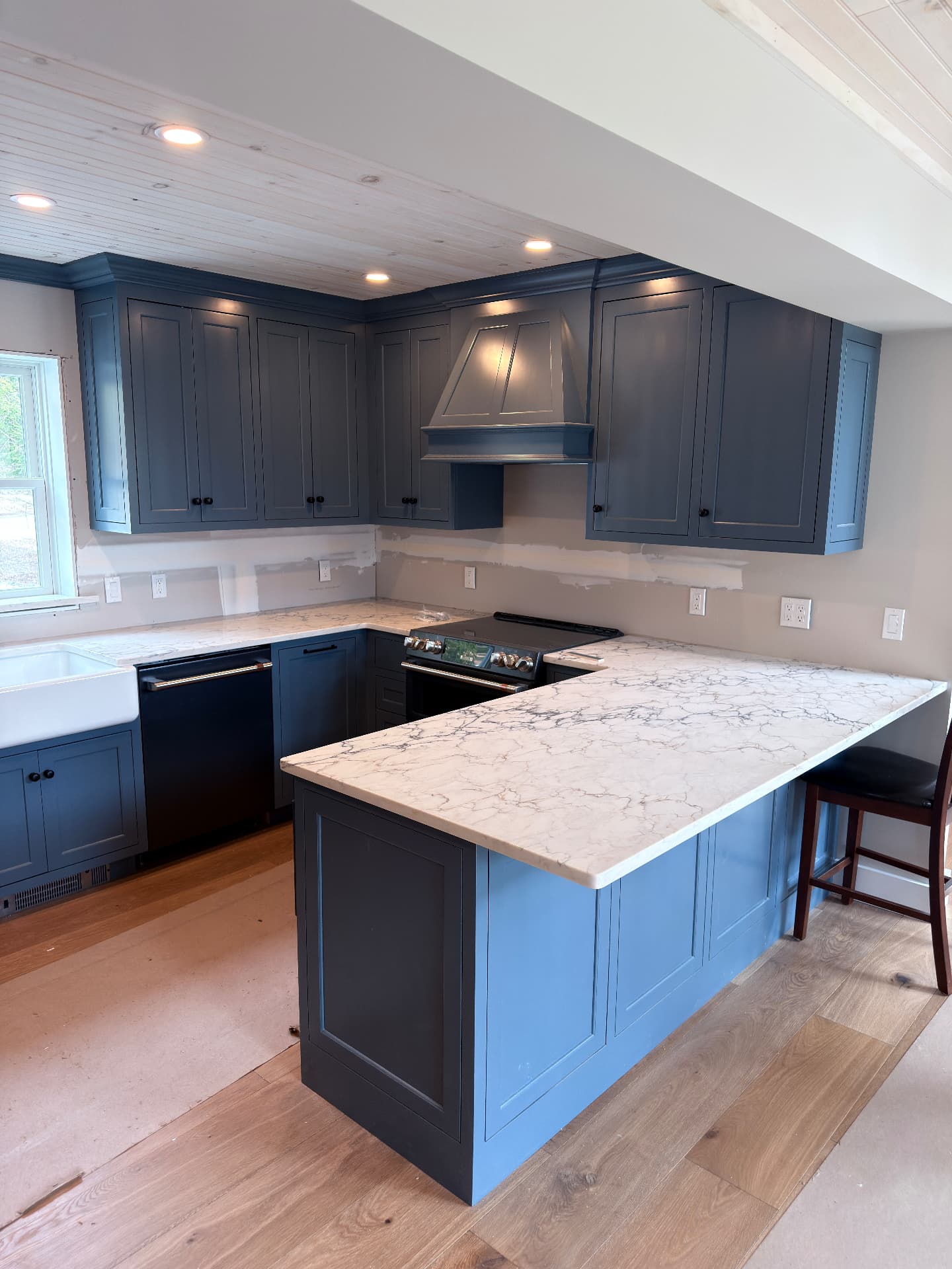 Blue kitchen with marble-look quartz peninsula
